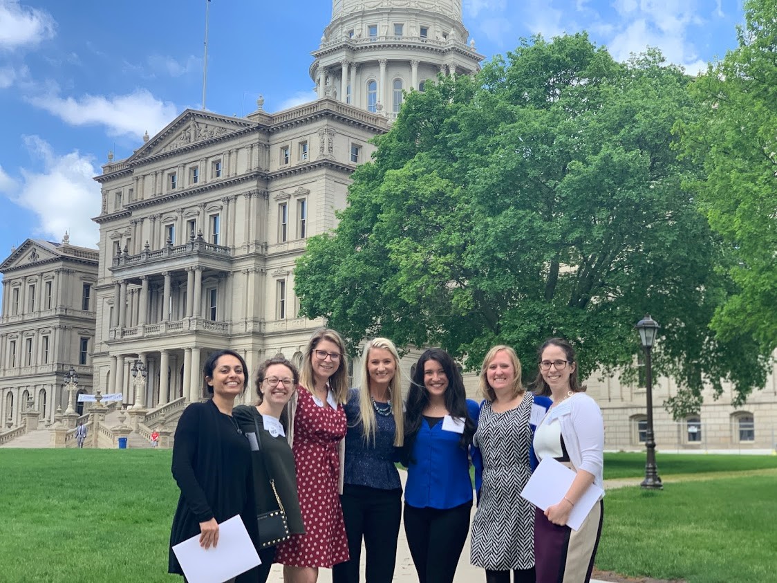 Residents standing in front of the Michigan capitol building in Lansing, MI